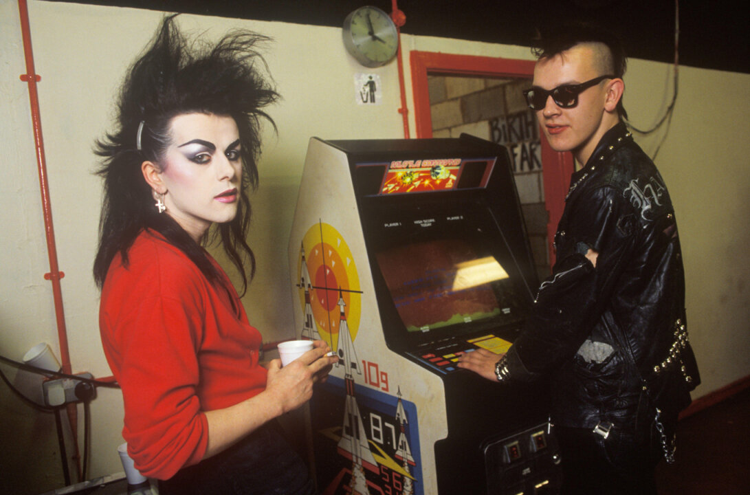 New Romantic student with Punk friend playing on a Space Invader machine, St Martin's School of Art London UK, 1985.
